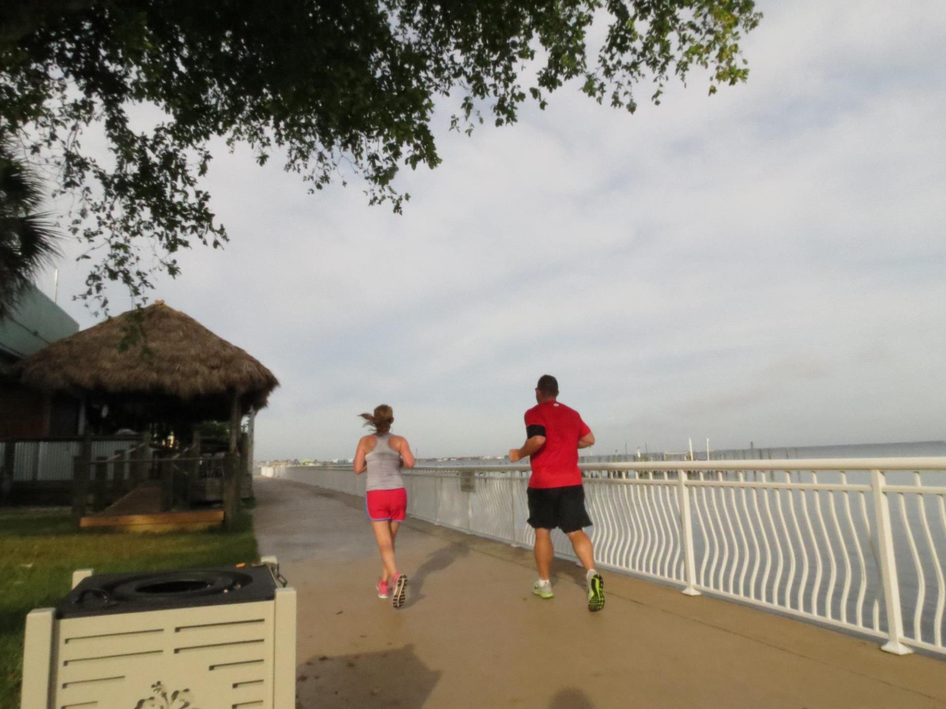 two people running along the harbor 