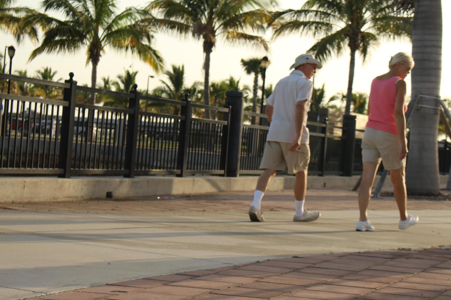 two people walking along the harbor during sunset