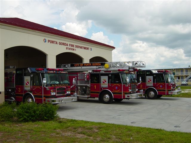 Photo of exterior - Fire Station 1 located at 1410 Tamiami Trail. Three fire trucks parked outside of garage doors.