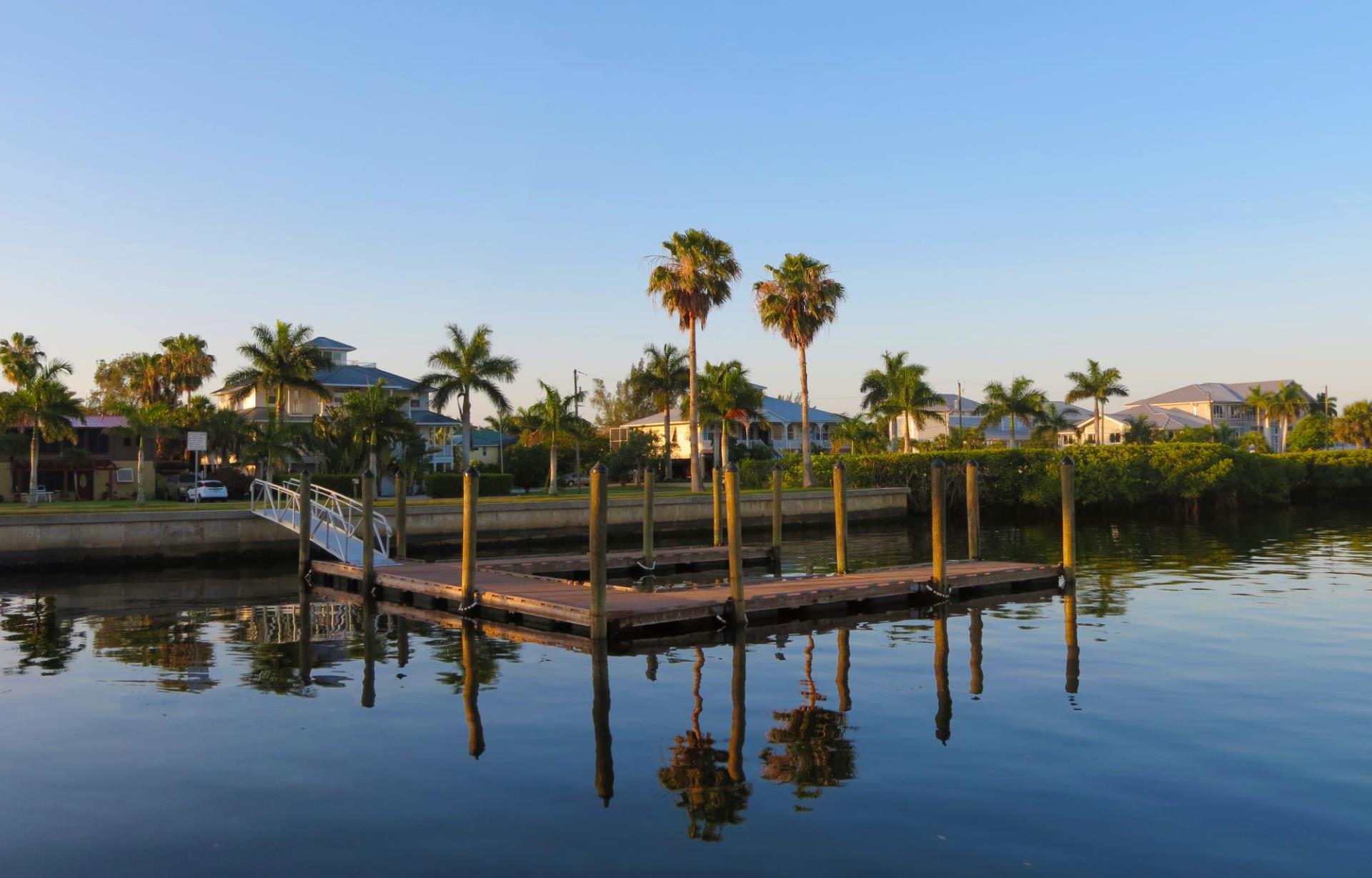 gilchrist docks along harbor with palm trees and houses in background