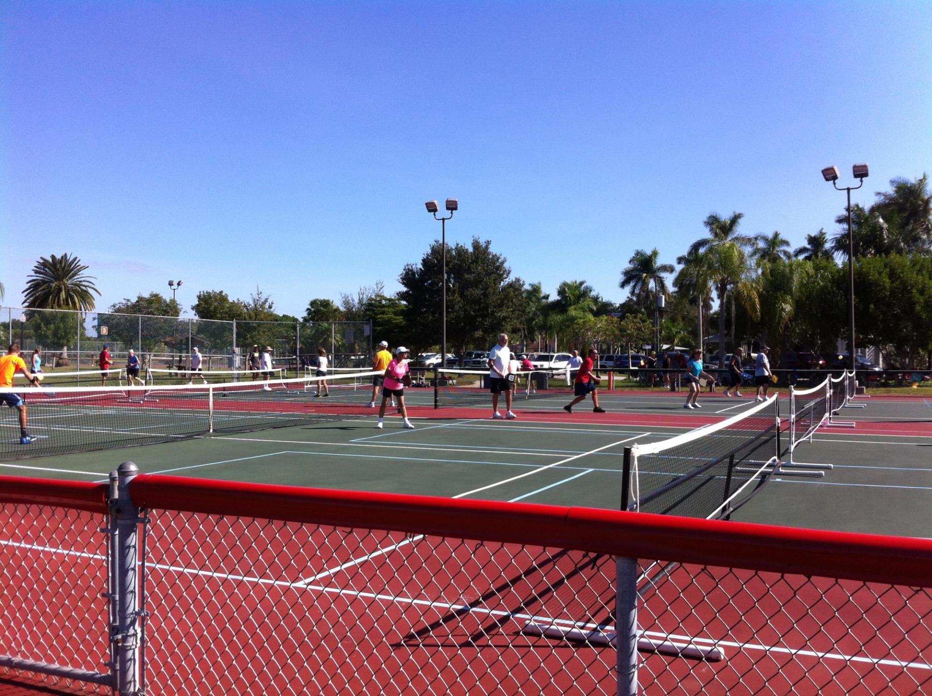 people playing in tennis courts in gilchrest park 