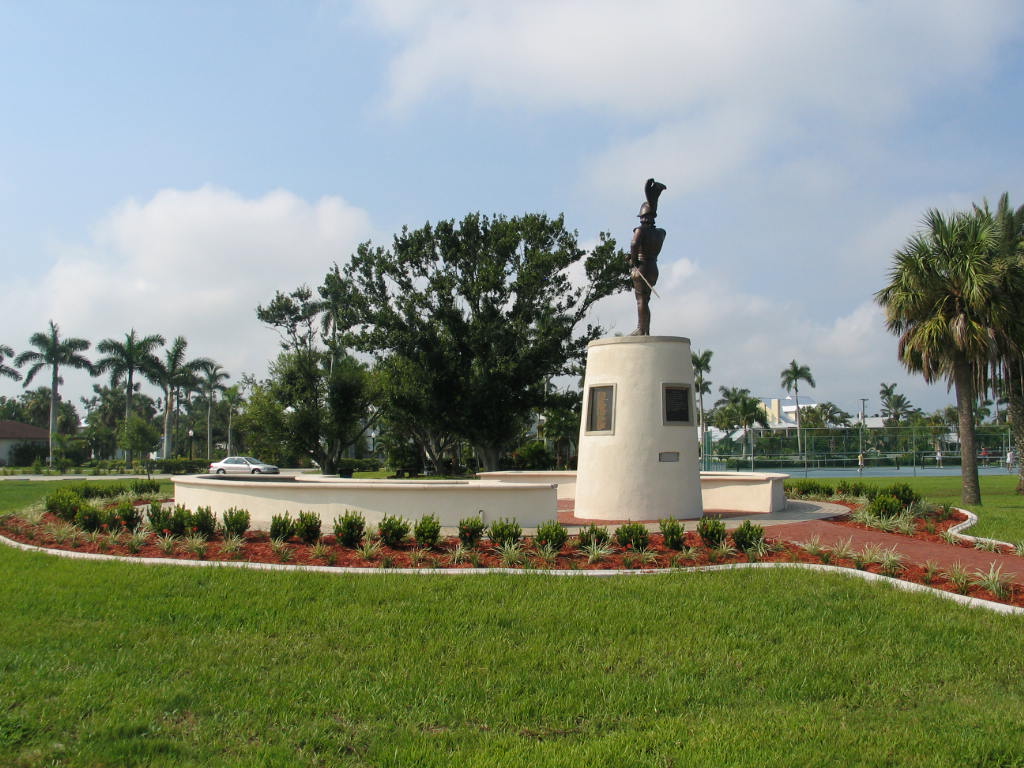 ponce statue with surrounding planters and tennis courts in the background