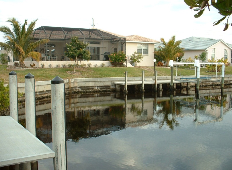 Dock in a canal with houses in the background,