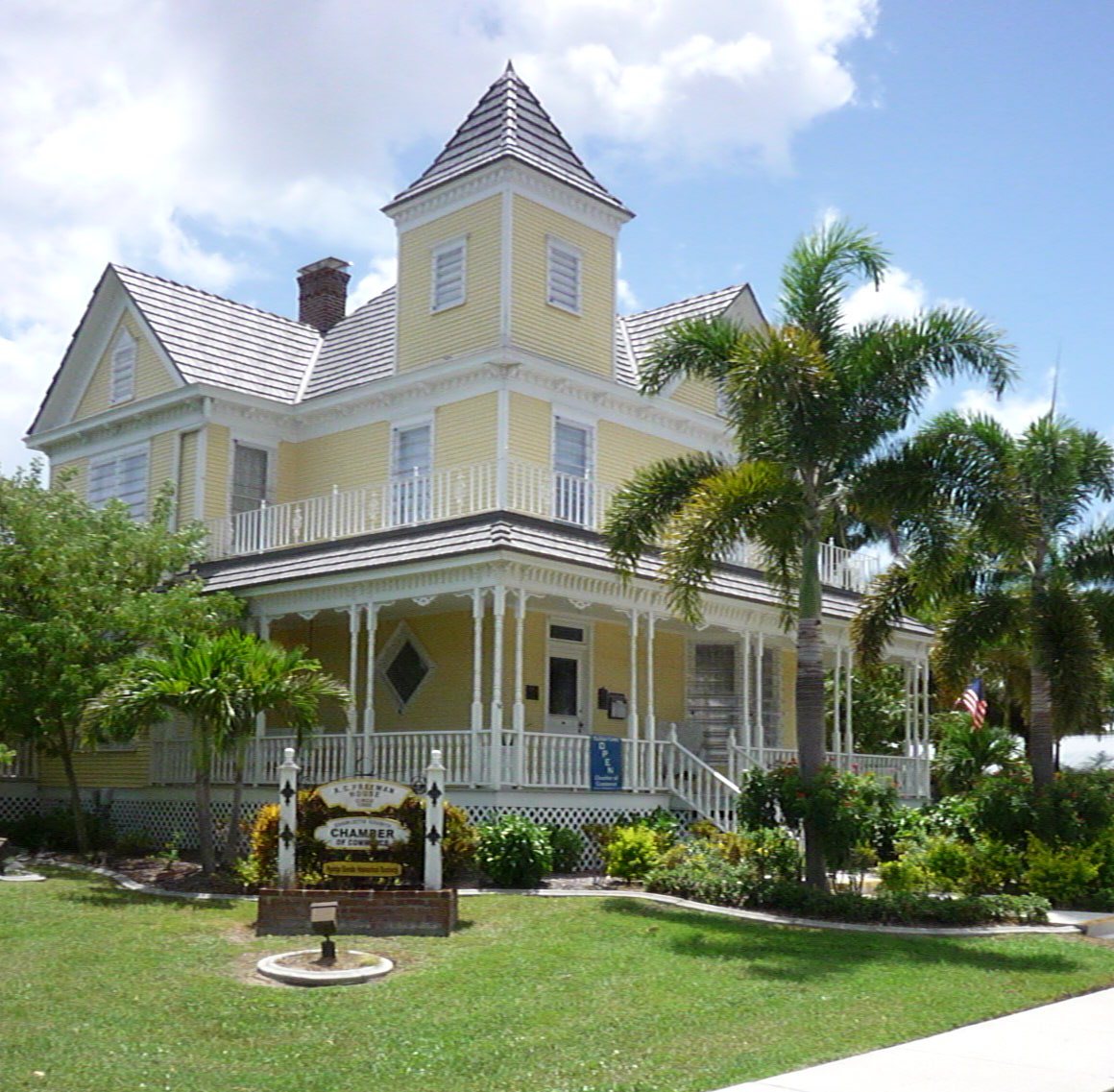 Freeman house. Two story home with wrapped porch. Surround by scrubs and trees.