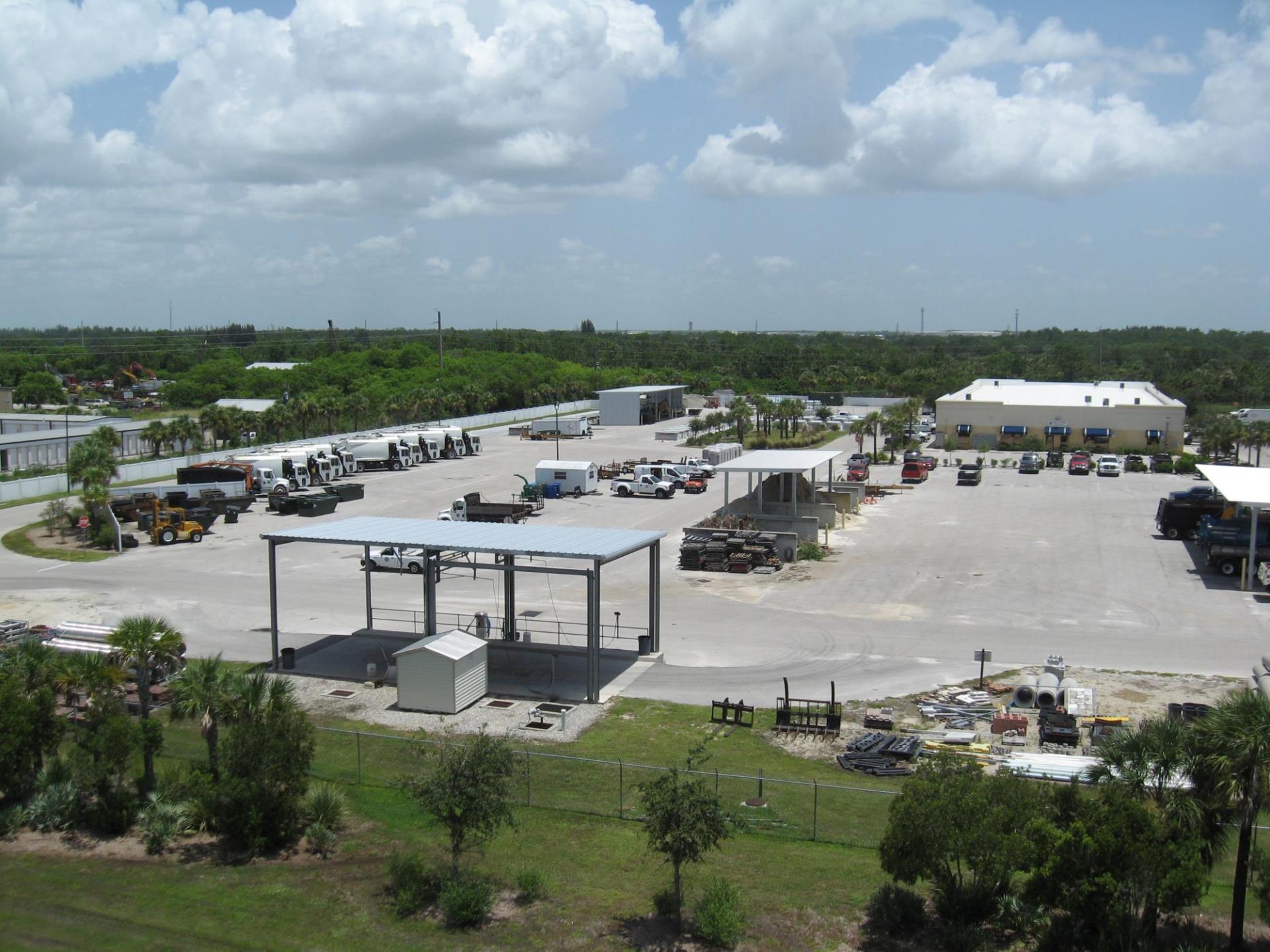 Sanitation parking lot with Public Works trucks and equipment parked.