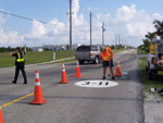 Street closure with Police Officer directing traffice while City Employee works.